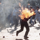A South Korean student engulfed in flames runs for safety as his compatriots launch home-made firebombs toward riot police during anti-government, anti-Olympic demonstrations at Korea University in Seoul, South Korea on Sept. 29, 1988. (Photo credit: AP)